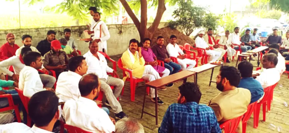 Members seated under a tree at the Lucknow meet