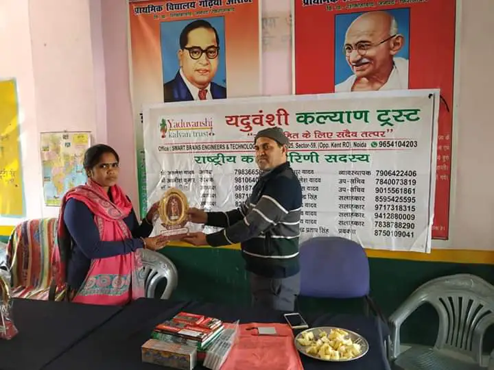 A student receives stationery from Trust members, Shikohabad
