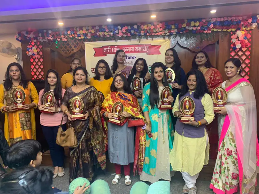Women honourees hold their awards on stage at Naari Shakti